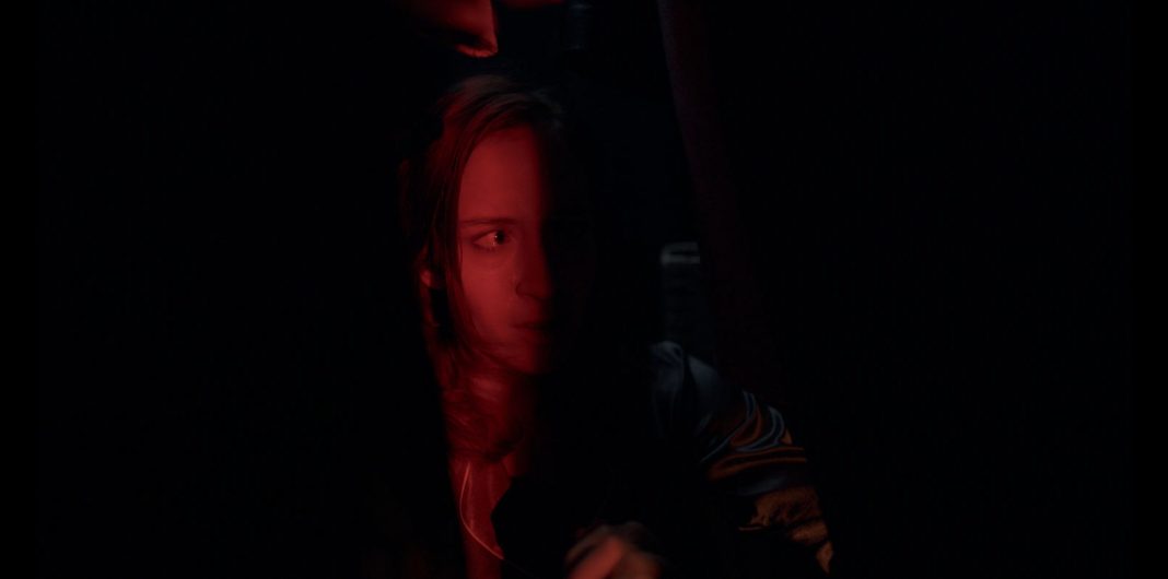 Crystal Loverro as Maria hiding in a dark closet from an alien predator in Blindsided (2025)